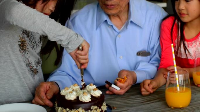 可爱的亚洲孙女在舒适的家庭4k用刀切生日蛋糕的前视图