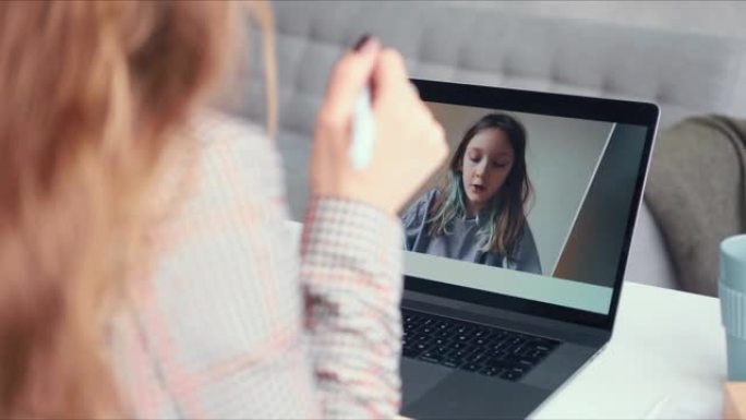 电子学习概念。POV金发女导师在笔记本电脑网络电话会议上领导在线课程与青少年女孩交谈。