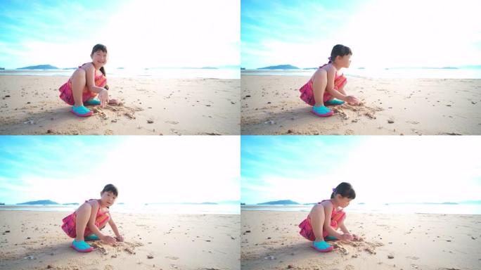 快乐的儿童女孩早上在沙滩上玩沙子