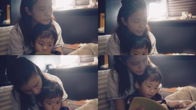 亚洲妈妈和小儿子晚上在床上看书。
