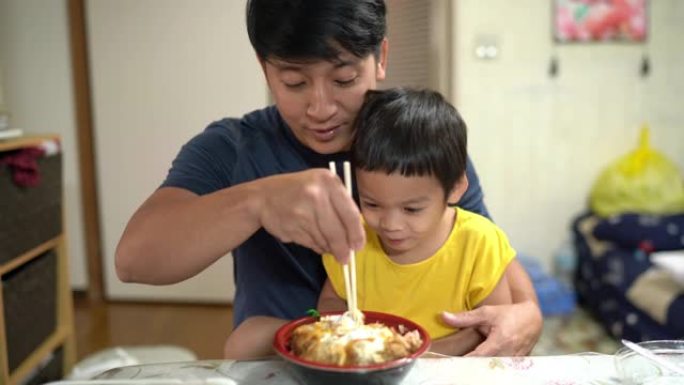 快乐的父子，小男孩喜欢吃katsudon，日本炒肉加米饭在家，2岁