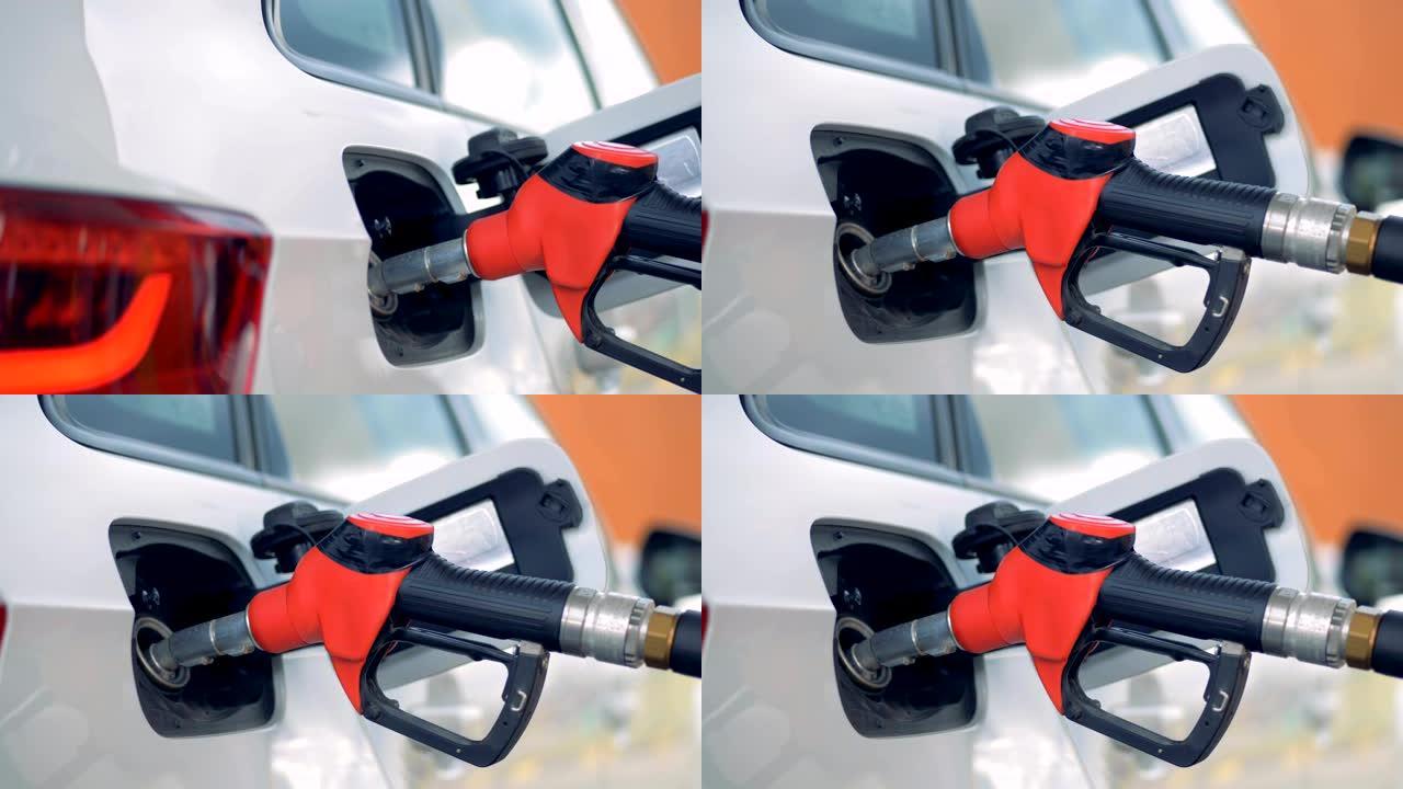 汽车油箱中的红色气体喷嘴，特写。