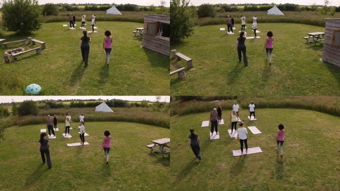 在户外瑜伽静修会上，成熟男女老师领导小组的无人机拍摄