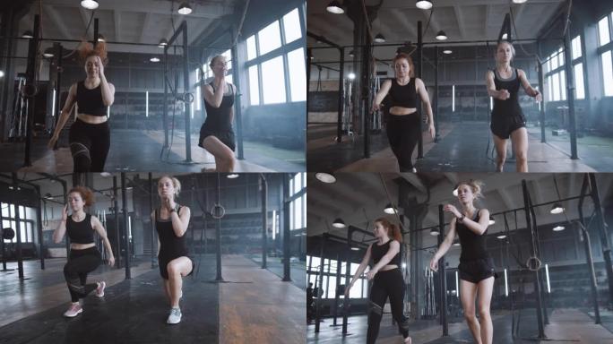 慢动作两个年轻漂亮的运动欧洲妇女一起在大气健身房做有氧运动。