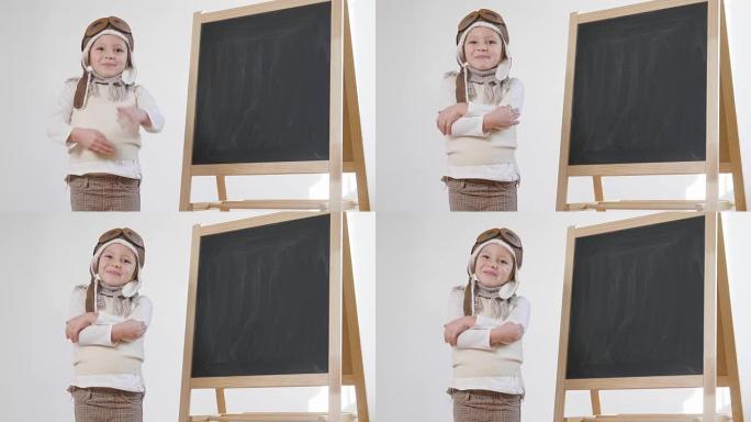 一个打扮成飞行员或飞行员的小女孩用手指示她身后的黑板作为飞行标志，以学习使用飞机和想象力。