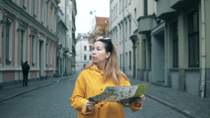 一个女人的前视图，一张地图走在城市街道上