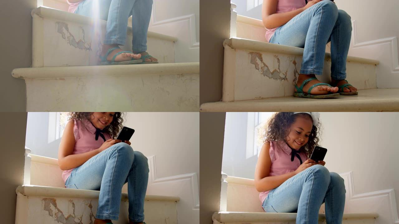 快乐黑人女孩在舒适的家庭4k楼梯上使用手机的低角度视角