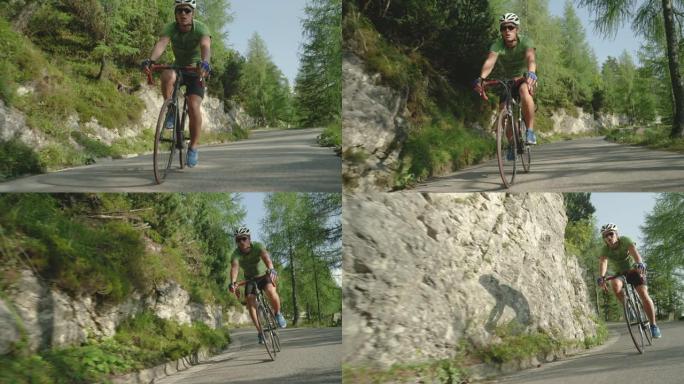慢动作: 年轻的公路骑自行车的人骑着他的新自行车在森林路上加速行驶。