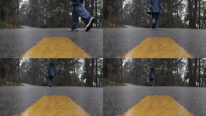 独自行走在林间公路上的摄影师