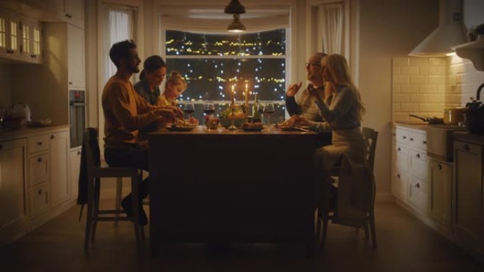 幸福的一家人一起庆祝，坐在餐桌旁吃着美味的晚餐。小孩，年轻的丈夫，妻子，祖父和祖母，讲故事，开玩笑，