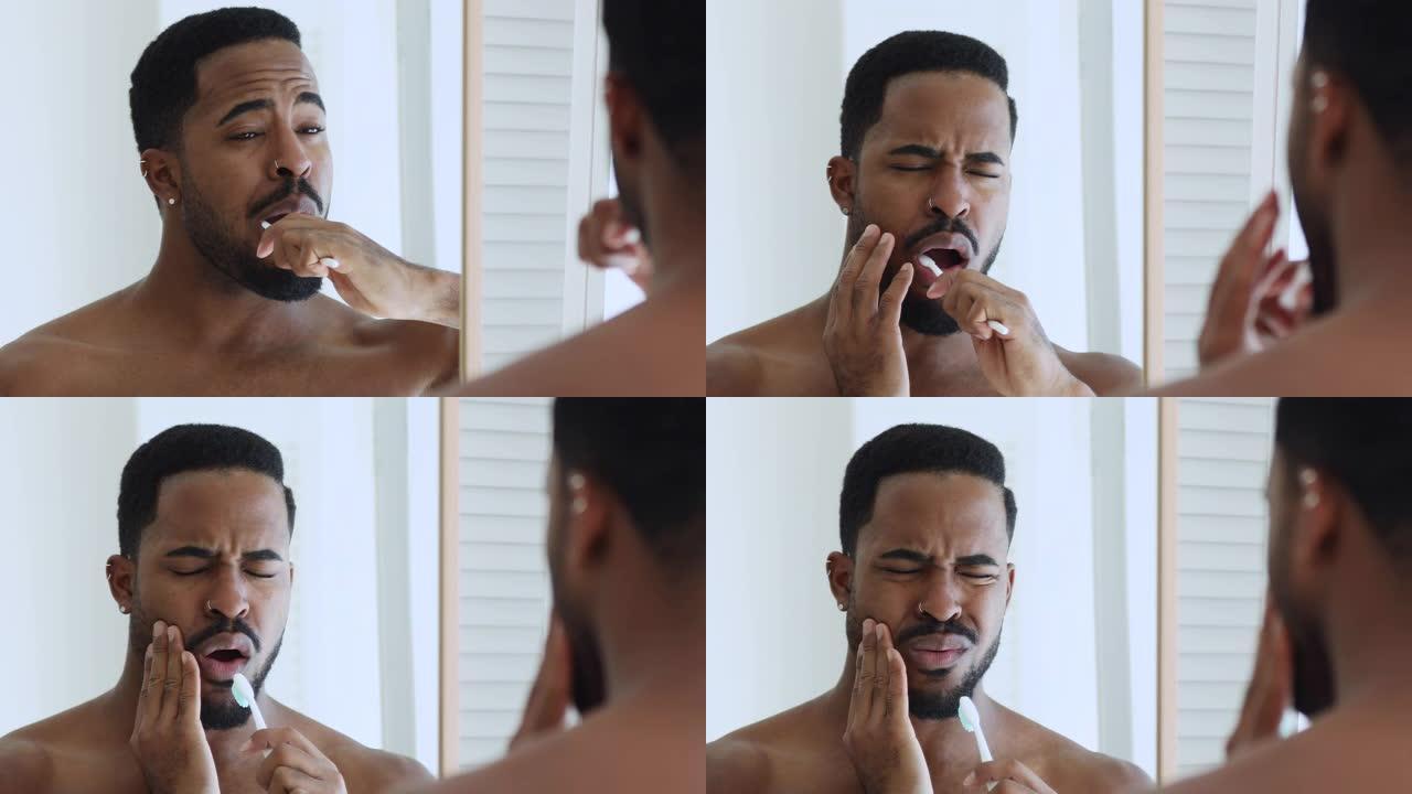 年轻的非洲裔美国男子刷牙感到牙痛