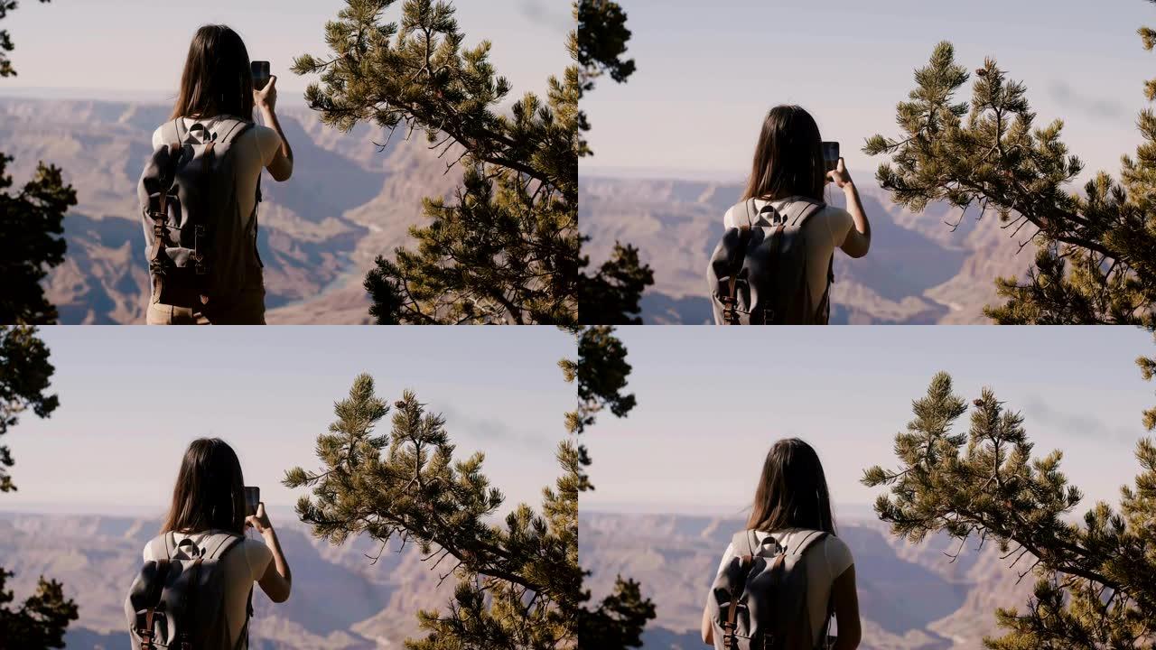 回顾快乐的旅游女人徒步旅行，拍摄令人惊叹的大峡谷国家公园山景的智能手机照片。