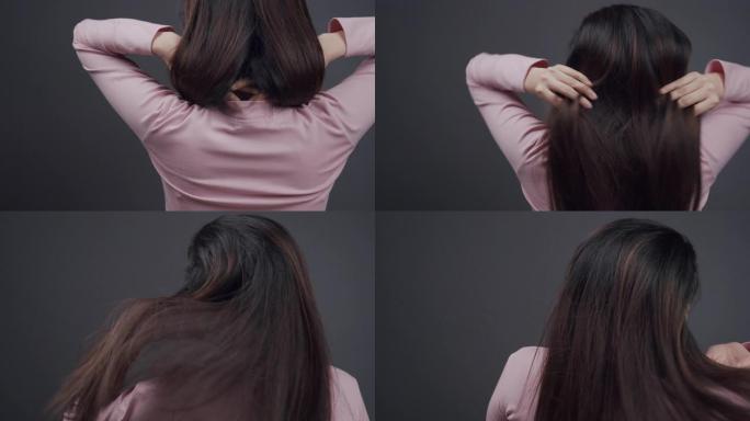 健康和美丽。迷人的亚洲女人或美丽的悲伤女孩，长损伤，蓬乱的头发在她的手。护发概念。高分辨率。