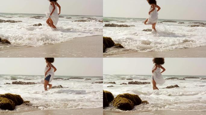非裔美国妇女在海滩上玩海水的侧视图4k