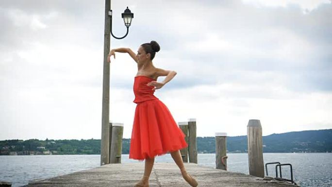 一位美丽的轻型芭蕾舞演员的肖像，穿着郁郁葱葱的红色连衣裙，而她正在跳舞。