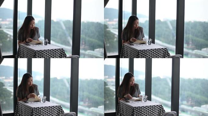 一名亚洲华裔年轻女子在公寓拐角处读书