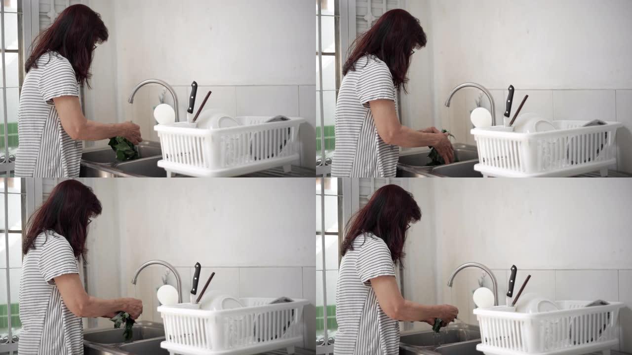 亚洲高级女性喜欢为家人清洗新鲜蔬菜。烹饪的概念