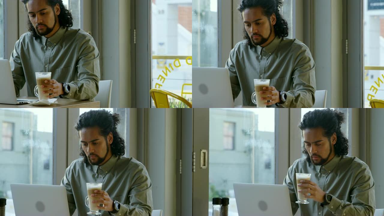 高管在使用笔记本电脑4k时喝咖啡