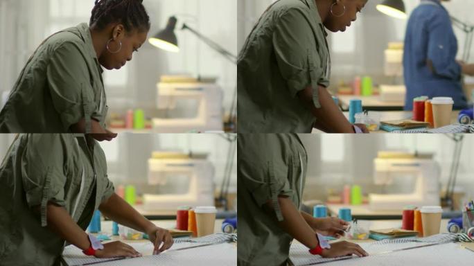 缝纫工作室用粉笔标记织物的非洲裁缝师