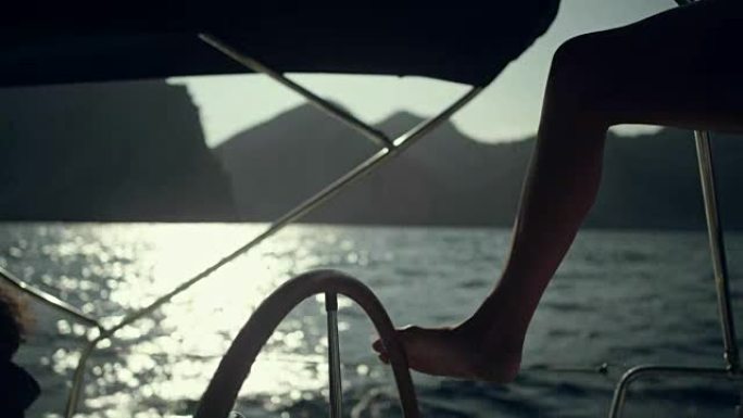 女人用腿操纵游艇。特写