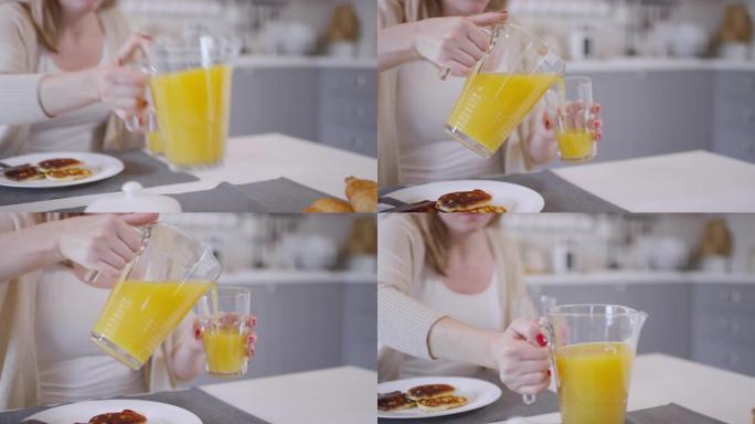 女人将橙汁倒入玻璃杯中