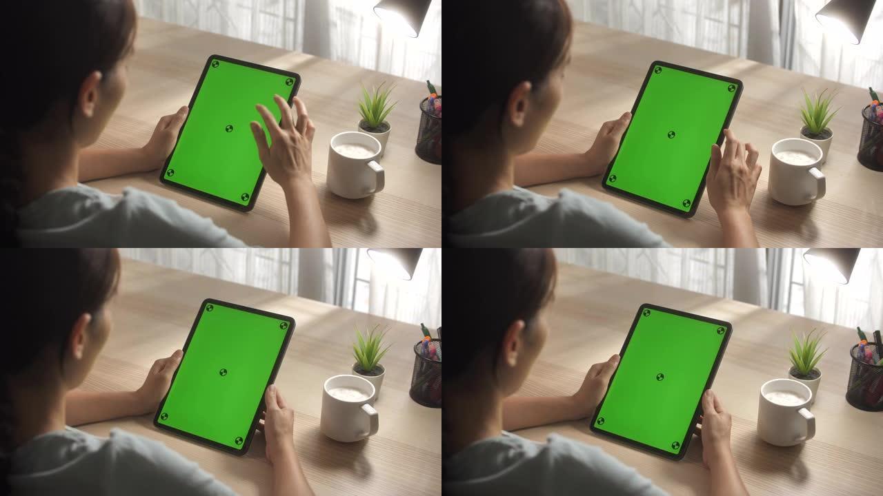 女人在垂直模式下使用绿色模拟屏幕数字平板电脑