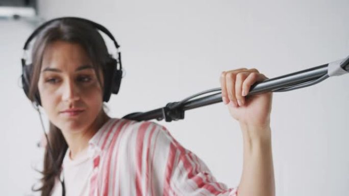 在白色工作室的视频电影制作中，女性录音师手持麦克风