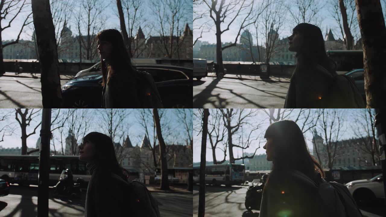 侧视图美丽的女人，背着背包，探索巴黎秋天繁忙的街道，在惊人的秋天早晨慢动作。
