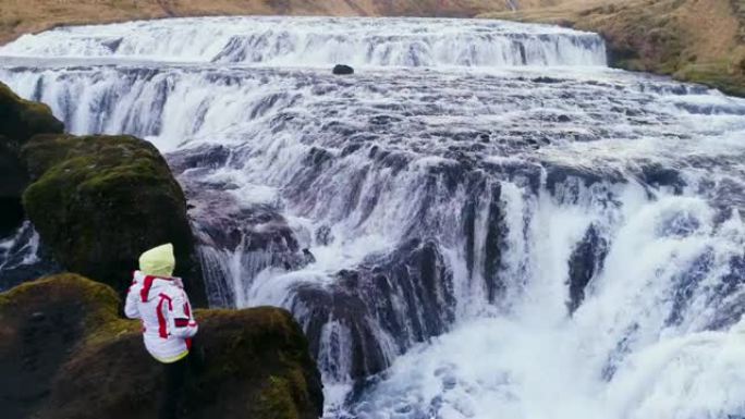 女士看着冰岛崎fall的瀑布