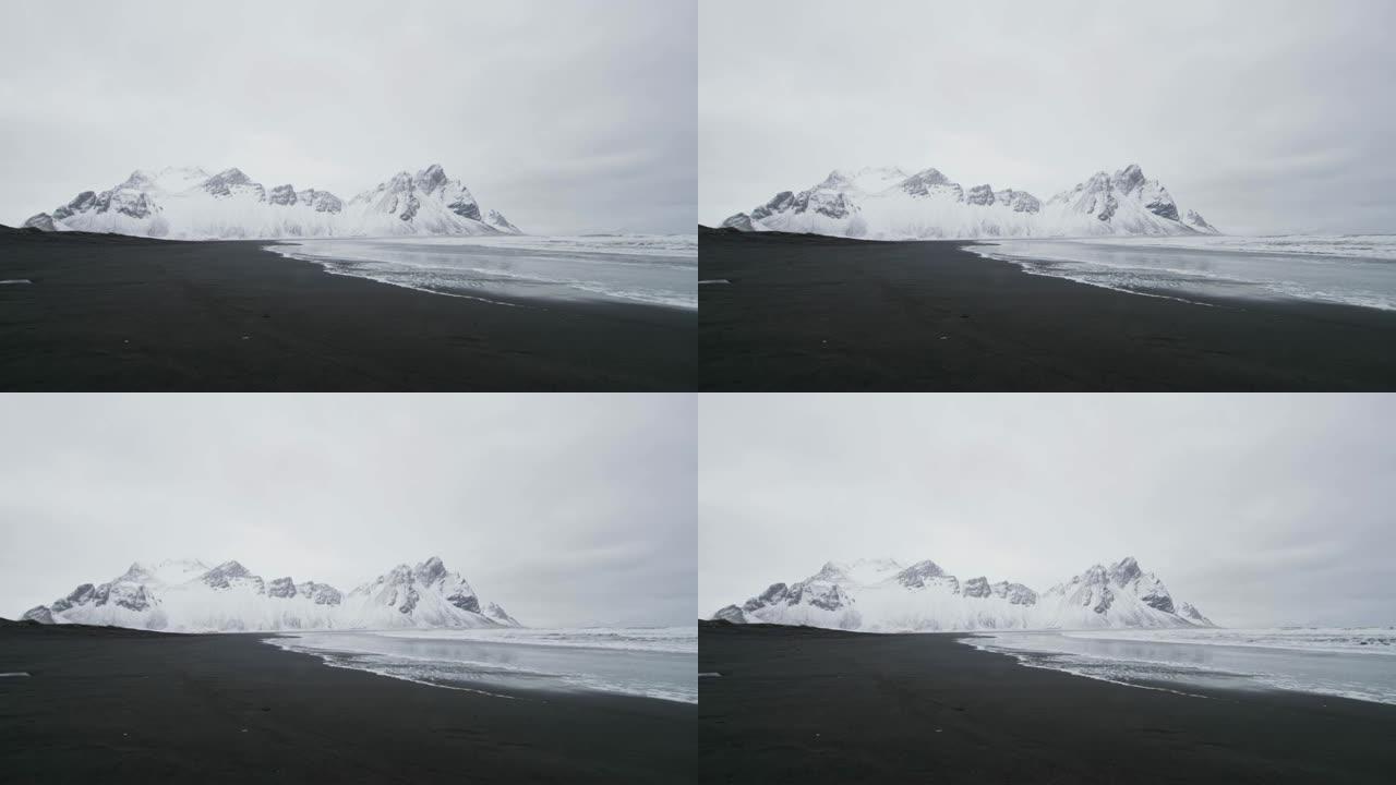 冰岛斯托克内斯海滩黑沙海滩外白雪覆盖的山脉