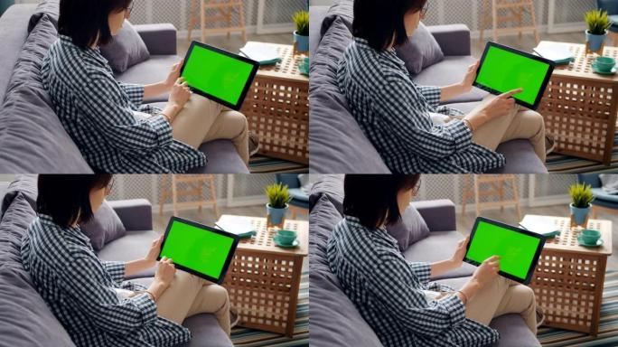 女孩的慢动作使用带有绿色模拟屏幕触摸显示器的平板电脑
