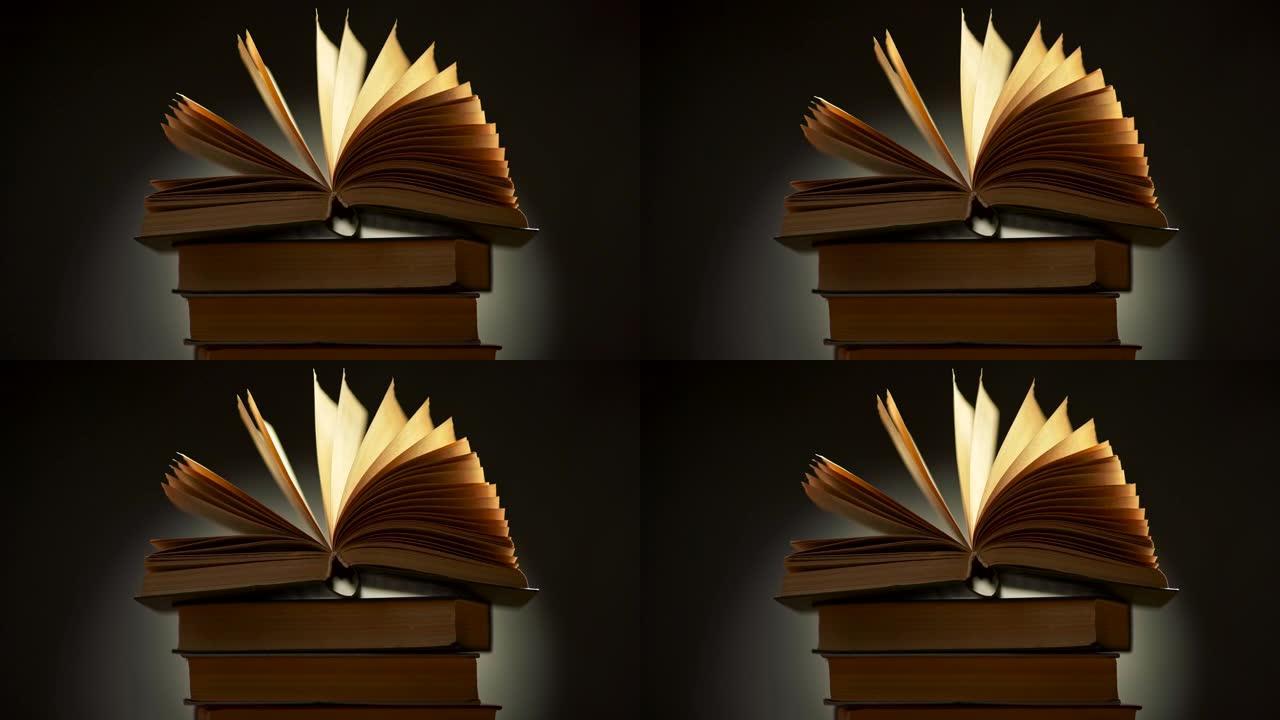 古老的老式书籍躺在一堆其他书籍上，挥舞着泛黄的书页。慢动作镜头