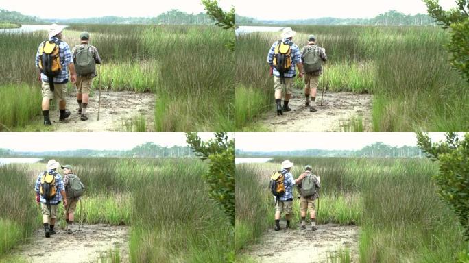 西班牙裔男孩和父亲徒步旅行，湿地景观