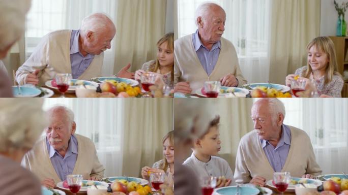 祖父在家庭晚宴上与孙子交谈