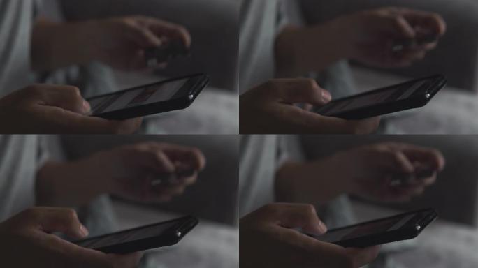 英俊的亚洲男子使用智能手机和信用卡进行在线购物