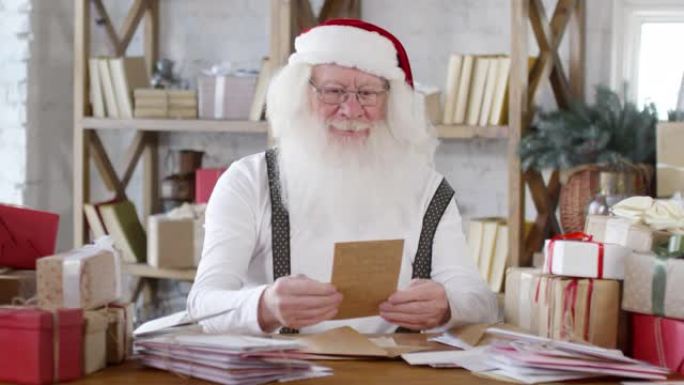 开朗的圣诞老人读信和笑