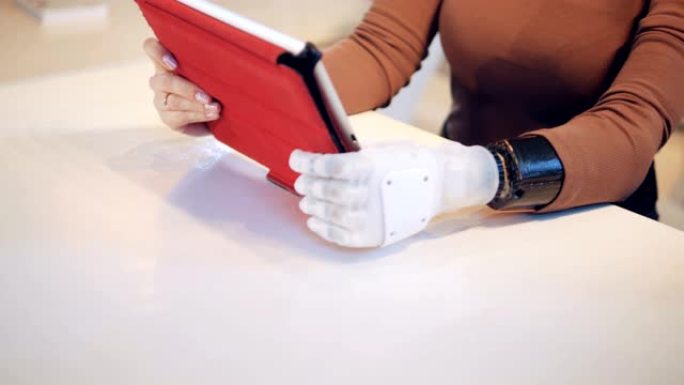 一个拥有机械臂的女人正在操作平板电脑