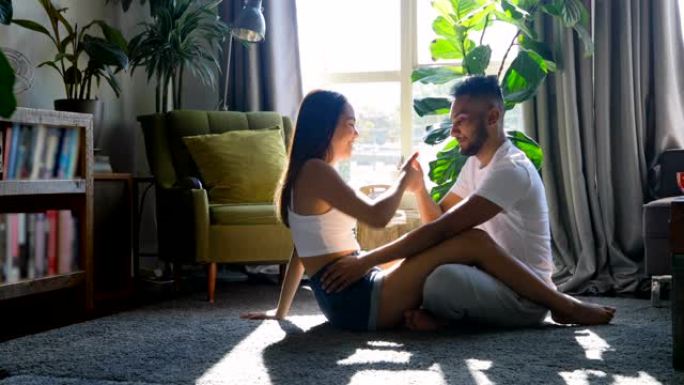 年轻的亚洲夫妇在家里4k的客厅一起玩的侧视图