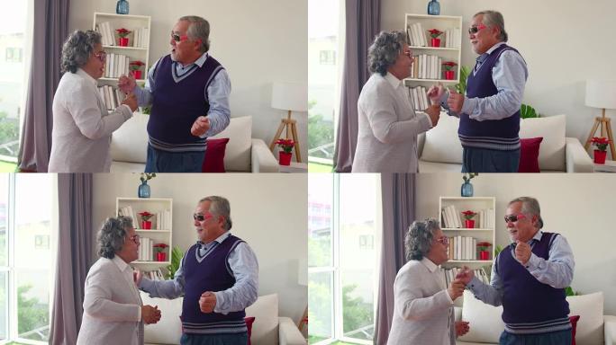 2老年人的行为像孩子一样戴着墨镜在他的房子里跳舞，这是一个快乐的退休生活的概念，没有压力。