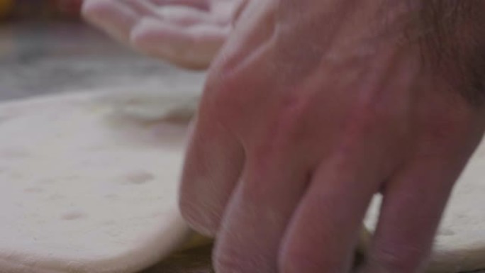 靠近披萨厨师的手揉捏面团，准备美味的披萨，然后撒上番茄酱。