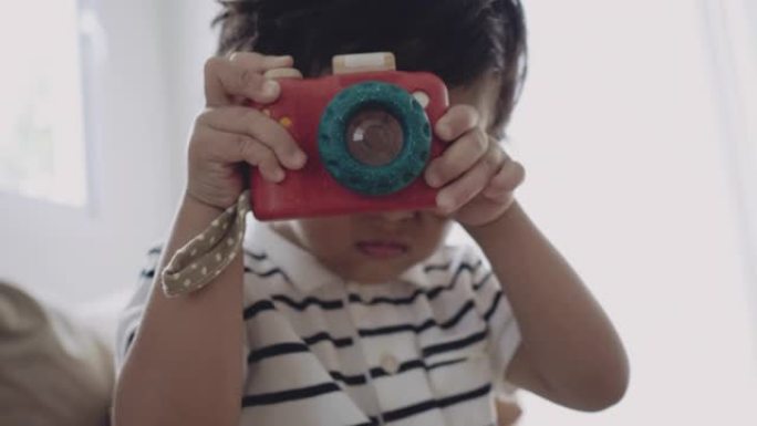 快乐的小男孩用玩具相机拍照