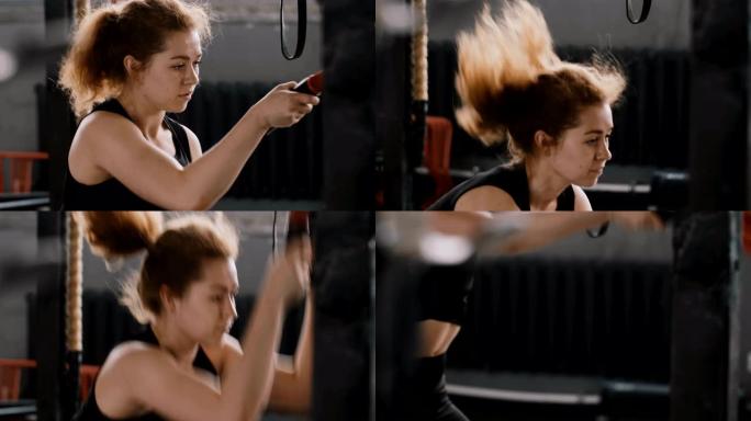 特写慢动作年轻美丽的运动红发女人在大型健身房用战斗绳锻炼，健康的生活方式