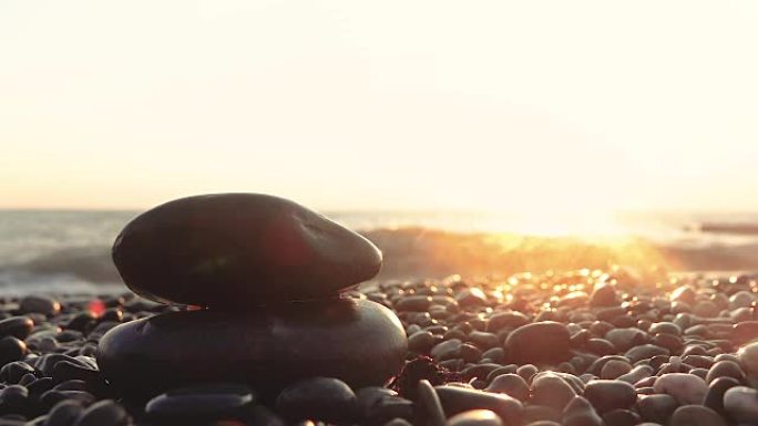 从岸边欣赏日落的美丽景色，前景是鹅卵石