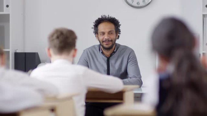 富有魅力的年轻黑人老师在课堂上与学童交谈