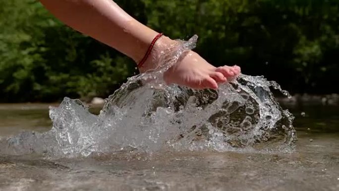 慢动作: 无法识别的脚踝手镯女人踢冻的水。