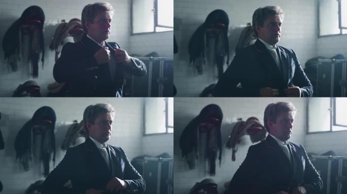 年轻男性马术大师的电影慢动作正在穿着专业服装，然后开始在骑马大厅练习赛马和盛装舞步比赛的练习