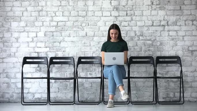 微笑的女性求职者使用笔记本电脑等待面试
