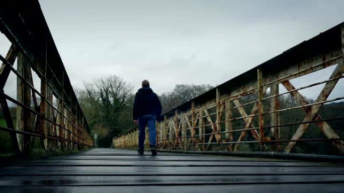 男子走在旧火车桥上