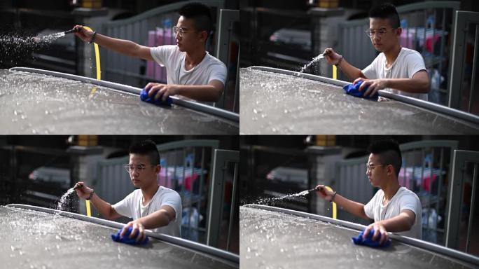 一个亚裔中国少年在他的房子前洗车
