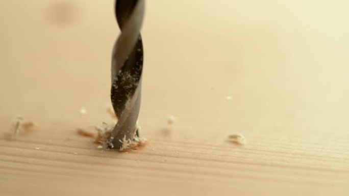 宏观: 锋利的金属钻头钻入木板的详细特写镜头。